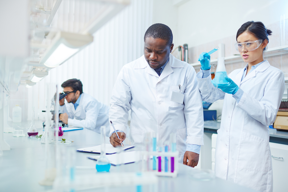 focused-female-asian-scientist-pouring-blue focused-female-asian-scientist-pouring-blue