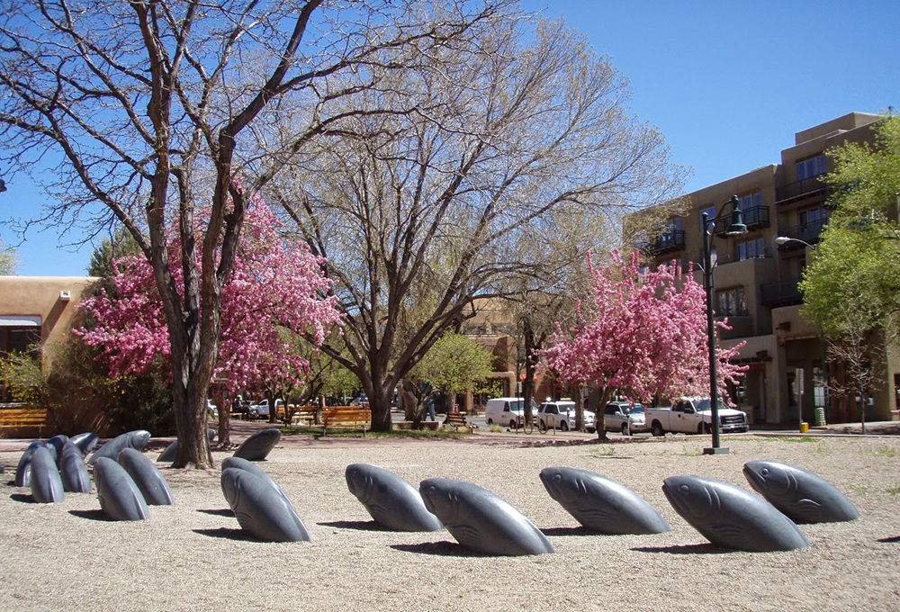 Santa Fe Plaza with blooming trees and fish sculptures
